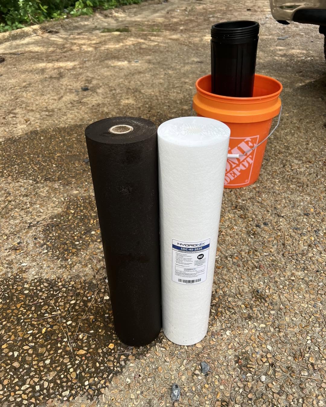 A dark, used water filter next to a clean new one, pulled from a central Mississippi home